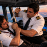 Illustrative cockpit scene showing two pilots in uniform during a confrontation inside an aircraft.